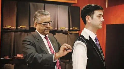 Raja Daswani Raja Daswani measuring customer for suit