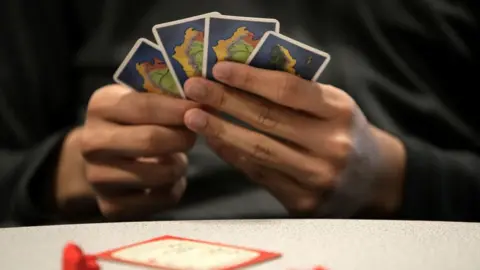 Getty Images Hand holds Catan cards