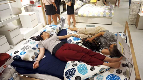 Getty Images People nap on a bed at an Ikea store to escape the heat outside in Hangzhou, China, in 2017 (Credit: Getty Images)
